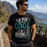 T-shirt noir inscription la vie est plus cool à vélo porté par un cycliste souriant