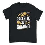T shirt avec l’inscription "Raclette is coming" porté par un fan de fromage devant un appareil à raclette.