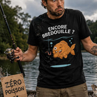 Homme pêcheur surpris et malchanceux au bord d'une rivière, entouré de poissons bondissants, avec une expression amusée et un T-shirt humoristique sur le thème de la pêche.