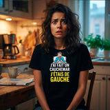 T-shirt noir en coton pour femme, porté par une jeune femme brune à l'air hagard et anxieux dans une cuisine au petit matin. Le t-shirt présente le visuel d'un homme en pyjama dans un lit avec le texte blanc et jaune "J'AI FAIT UN CAUCHEMAR J'ÉTAIS DE GAUCHE"