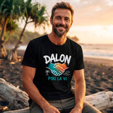 T-shirt noir en coton porté par un homme sur une plage tropicale à La Réunion, avec le design "DALON POU LA VI" et les mains en poignée de main bicolore