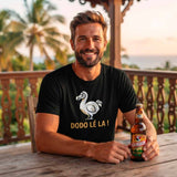 T-shirt noir pour homme en coton, porté par un homme barbu souriant sur une terrasse ensoleillée de La Réunion, avec le logo de la bière "BOURBON" (la bière Dodo) en gros plan