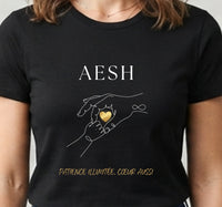 Tee-shirt noir pour femme avec une main d'adulte tenant une main d'enfant et un cœur doré, message AESH patience illimitée, cœur aussi