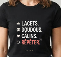 Tee-shirt noir pour femme avec la liste lacets, doudous, câlins, répéter et une flèche de boucle infinie, humour ATSEM
