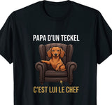 Tee-shirt noir pour homme avec un teckel installé dans un fauteuil de direction et le message papa d'un teckel, c'est lui le chef