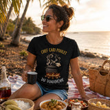 Femme portant un t-shirt noir avec le design « Chef Cari Poulet du Dimanche » lors d'un pique-nique au bord de la plage avec un repas créole à La Réunion