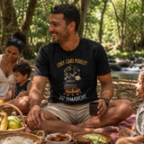 Homme portant un t-shirt noir avec le design « Chef Cari Poulet du Dimanche » lors d'un pique-nique en famille dans une forêt à La Réunion.