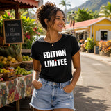Femme portant un t-shirt noir avec le design « Edition Limitée » dans un marché créole en plein air à La Réunion.
