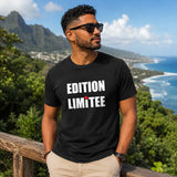 Jeune homme portant un t-shirt noir avec le design « Edition Limitée » face au littoral et à l'océan de l'île de La Réunion.