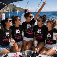 Groupe de femmes portant un t-shirt noir avec le design « Gang de la Mariée » lors d'un enterrement de vie de jeune fille à bord d'un bateau en mer, avec la future mariée au centre portant un voile et un diadème.
