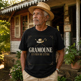 Homme âgé portant un t-shirt noir avec le design « Gramoune et fier de l'être » devant une case créole traditionnelle à La Réunion