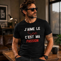 Homme portant un t-shirt noir avec le design « J'aime le Sexe c'est ma Passion » dans un loft moderne avec une attitude confiante et décontractée.