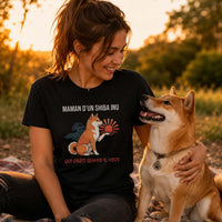 Femme portant un t-shirt noir avec le design « Maman d'un Shiba Inu qui obéit quand il veut » assise dans un parc au coucher du soleil avec son chien Shiba Inu à ses côtés.