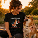 Femme portant un t-shirt noir avec le design « Maman d'un Shiba Inu qui obéit quand il veut » assise dans un parc au coucher du soleil avec son chien Shiba Inu à ses côtés.