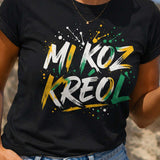 Femme portant un t-shirt noir avec le design « Mi Koz Kréol » en pleine discussion avec une amie sur une promenade en bord de mer.