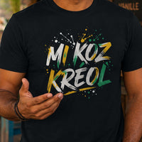 Homme portant un t-shirt noir avec le design « Mi Koz Kréol » en train de discuter avec un autre homme devant un bar créole tropical.
