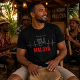 Homme portant un t-shirt noir avec le design « Mon Cœur Bat Maloya » en jouant du roulèr lors d'une soirée maloya traditionnelle dans une cour créole à l'île de La Réunion.