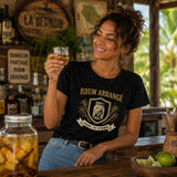 Femme portant un t-shirt noir avec le design « Rhum Arrangé » tenant un petit verre de rhum arrangé dans un bar créole à La Réunion