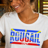 Femme portant un t-shirt blanc avec le design « Rougail 974 » en préparant un rougail saucisse dans une cuisine créole traditionnelle de La Réunion.