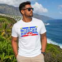 Jeune homme portant un t-shirt blanc avec le design « Rougail 974 » admirant le paysage côtier de La Réunion sous un ciel ensoleillé.
