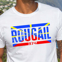 Homme portant un t-shirt blanc avec le design « Rougail 974 » face aux falaises et au littoral de l'île de La Réunion.