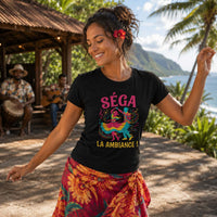 Femme portant un t-shirt noir avec le design « Séga La Ambiance ! » en train de danser le séga réunionnais devant des musiciens dans un décor tropical à La Réunion.