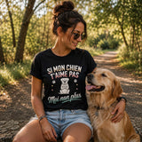 Femme portant un t-shirt noir avec le design « Si mon chien t'aime pas, moi non plus » assise avec son chien lors d'une balade en pleine nature.